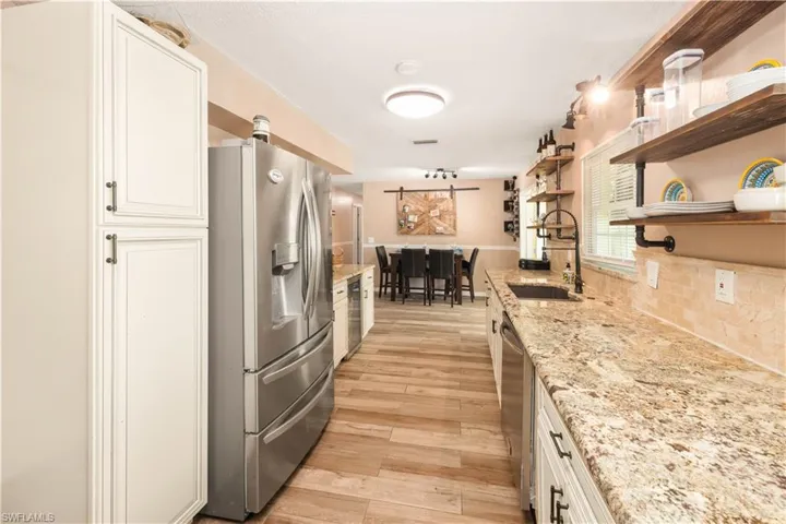 Kitchen has lots of prep space and storage with custom cabinetry and farmhouse open shelving