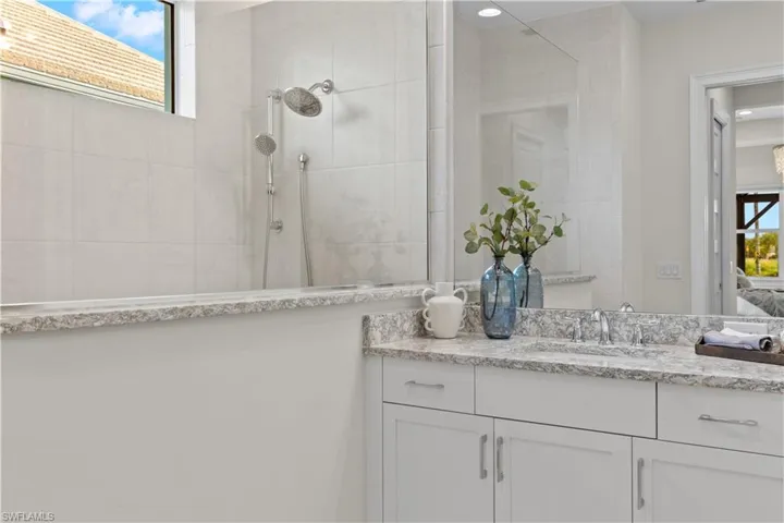Bathroom with tiled shower and vanity