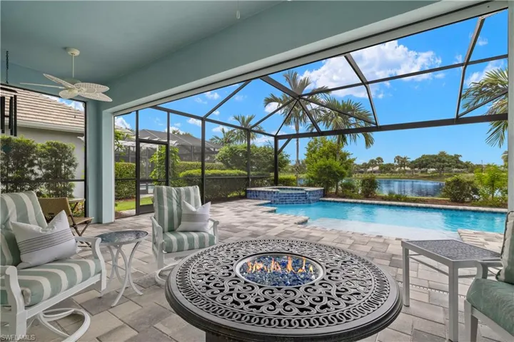 View of swimming pool featuring in ground hot tub, a water views, ceiling fans, and storm smart screens