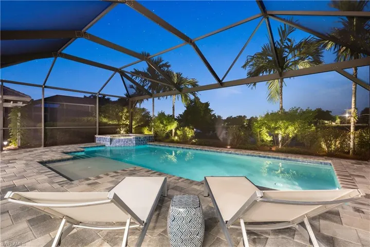 View of swimming pool featuring picture window screened lanai, in ground hot tub, and pool sun deck with bubbler.