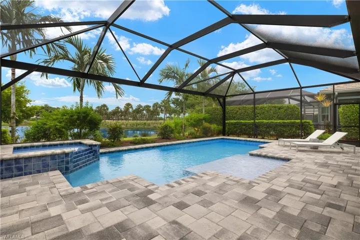 View of pool with an in ground hot tub, and screened lanai