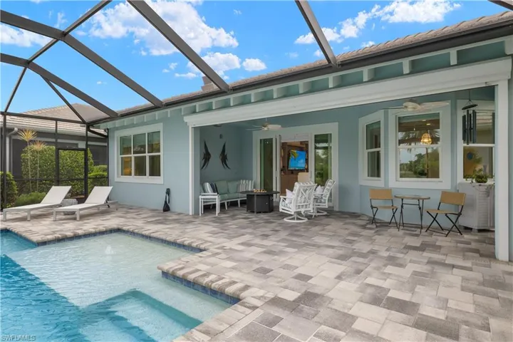 View of pool featuring a pool sun deck with bubbler, storm smart screens, ceiling fan, and a screened lanai