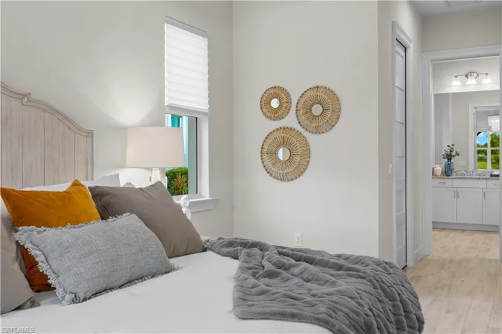 Bedroom with light hardwood / wood-style flooring and connected bathroom