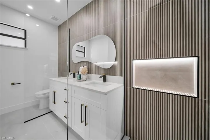 Full bath featuring visible vents, double vanity, a sink, and toilet