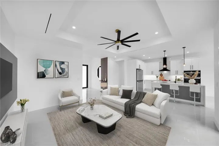 Living room featuring recessed lighting, a raised ceiling, light tile patterned flooring, ceiling fan, and baseboards