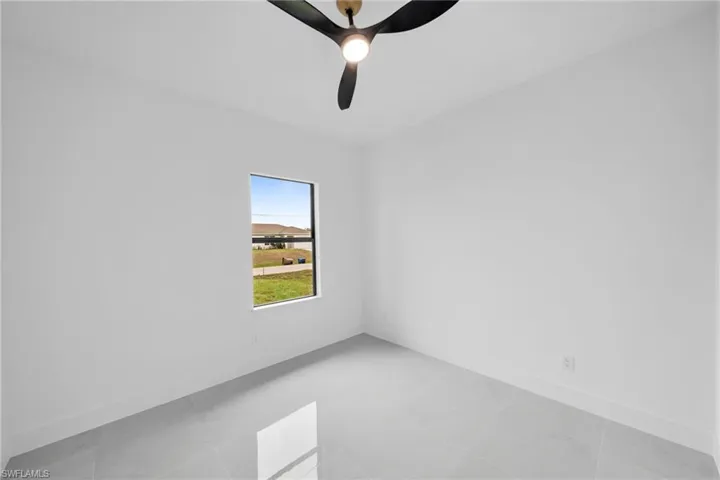 Unfurnished room with a ceiling fan and baseboards