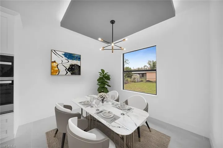 Dining space with a chandelier, light tile patterned flooring, and baseboards