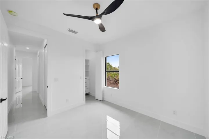 Unfurnished bedroom featuring a ceiling fan, visible vents, and baseboards
