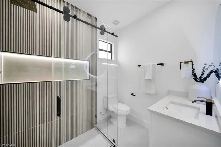 Bathroom featuring visible vents, toilet, a shower stall, vanity, and tile patterned floors