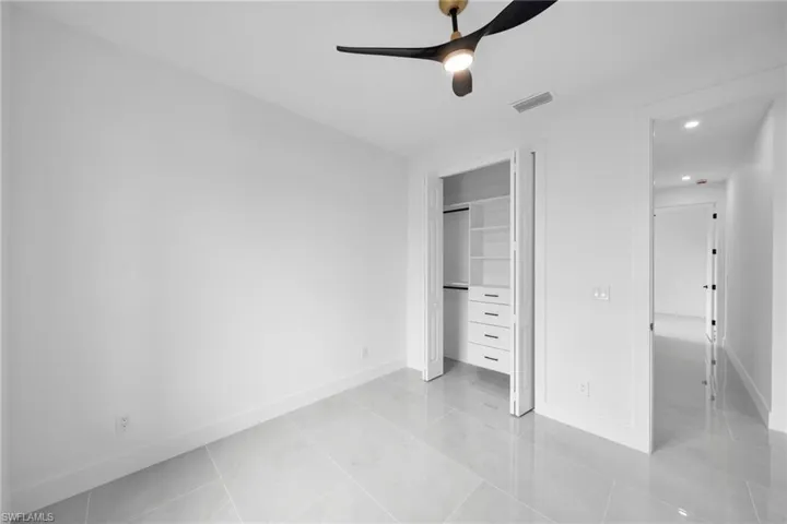 Unfurnished bedroom featuring ceiling fan, a closet, visible vents, and baseboards