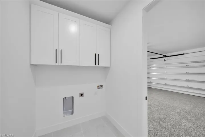 Washroom with baseboards, hookup for a washing machine, cabinet space, and electric dryer hookup