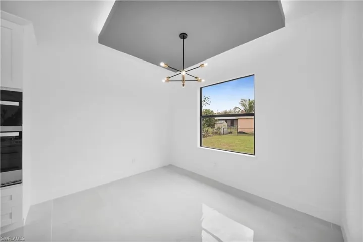 Unfurnished dining area featuring baseboards and a chandelier