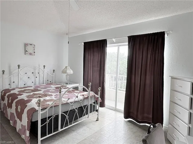Bedroom featuring access to outside, a textured ceiling, and ceiling fan
