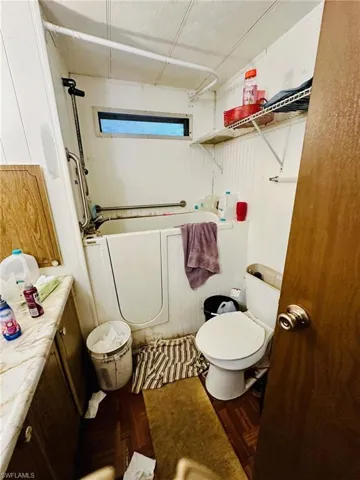 Full bathroom featuring vanity, toilet, bathing tub / shower combination, and parquet flooring