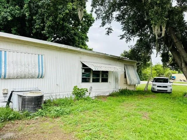 View of home's exterior featuring central AC unit and a yard