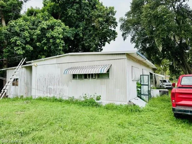 View of outbuilding with a lawn