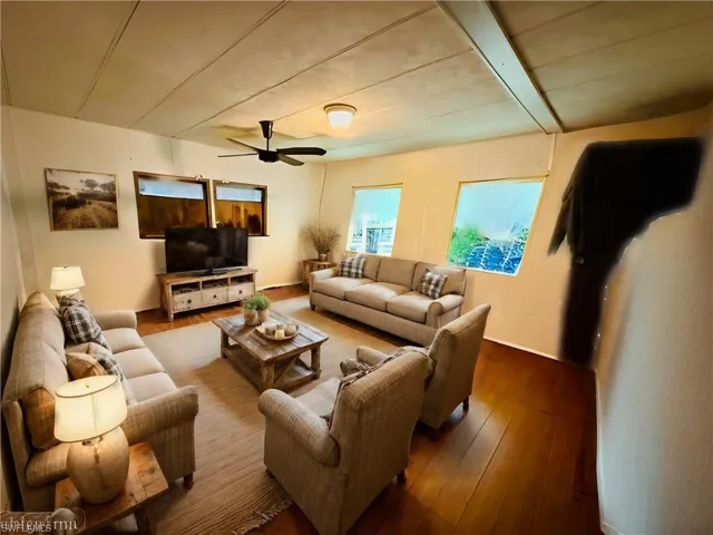 Virtually Staged: Living room featuring hardwood / wood-style flooring and ceiling fan
