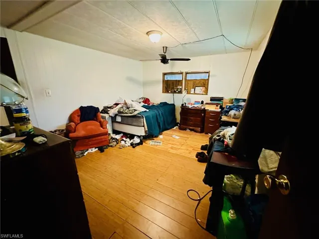 Bedroom with ceiling fan and hardwood / wood-style flooring