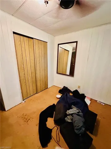 Bedroom with wooden walls and a closet