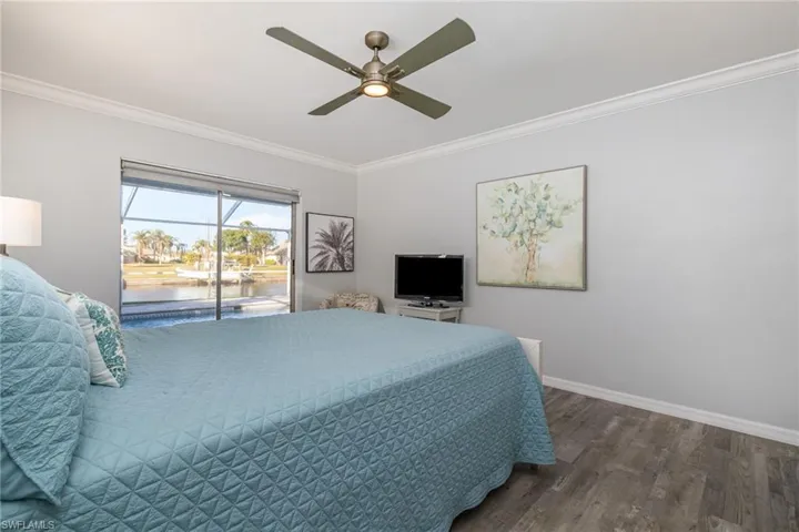 Bedroom with crown molding, dark hardwood / wood-style floors, access to exterior, and ceiling fan