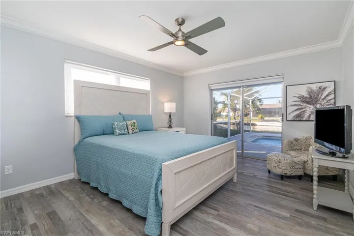 Bedroom with crown molding, wood-type flooring, access to outside, and ceiling fan