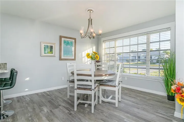 Dining area with hardwood / wood-style flooring and a notable chandelier
