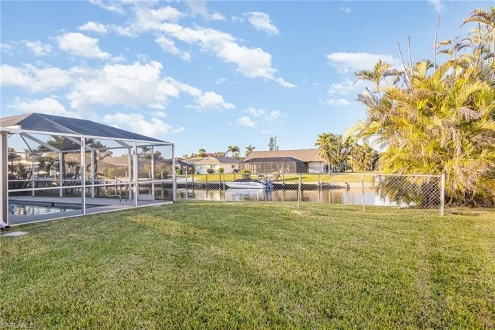 View of yard with glass enclosure and a water view
