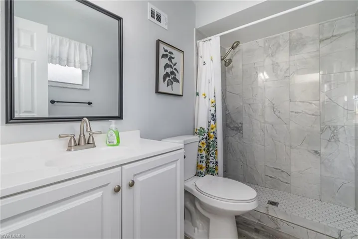Bathroom featuring vanity, toilet, and a shower with shower curtain