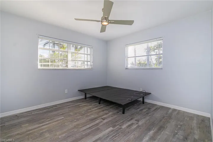 Unfurnished room with dark hardwood / wood-style floors and ceiling fan