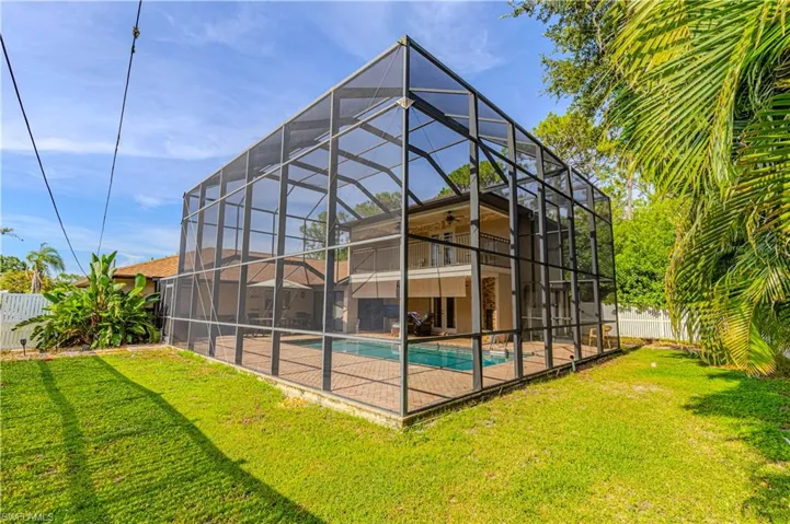 Back of house featuring a fenced backyard, an outdoor pool, a patio, ceiling fan, and glass enclosure