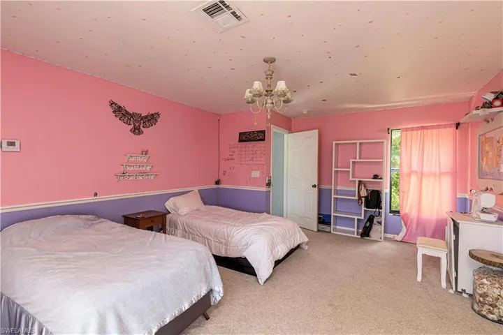 Bedroom with carpet and a chandelier