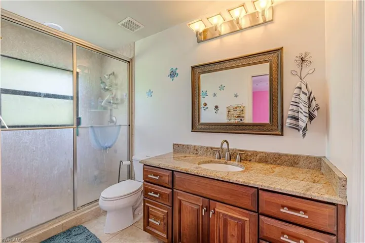 Full bath featuring vanity, a stall shower, and tile patterned floors