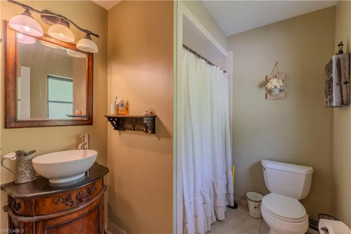 Full bath featuring vanity, tile patterned floors, and curtained shower