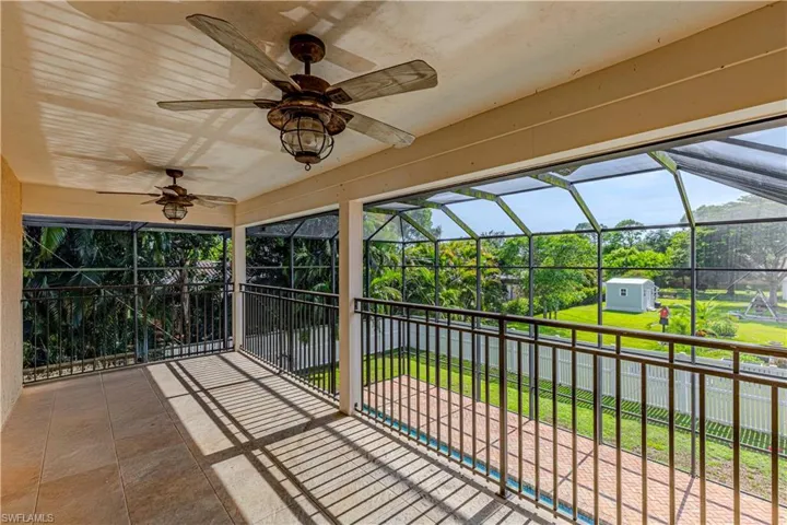 View of patio / terrace with ceiling fan, a shed, and a lanai