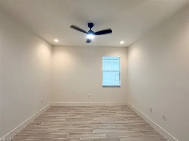 Room featuring wood-finish flooring, recessed lighting, and a central ceiling fan with integrated light fixture