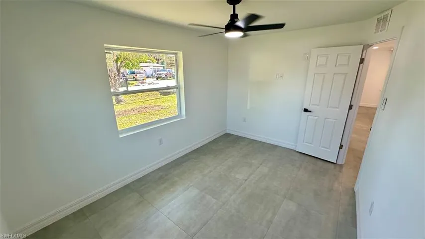 Unfurnished bedroom with baseboards, visible vents, and ceiling fan