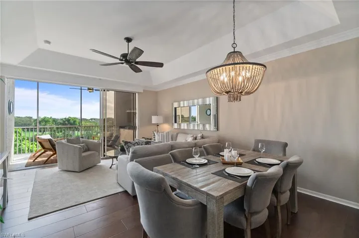 Great room with a vaulted ceiling, wood floors, custom lighting and crown molding.