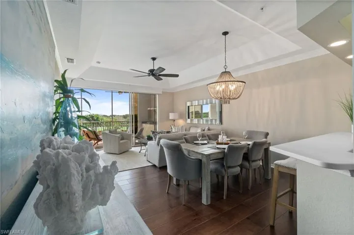 Great room with a vaulted ceiling, wood floors, custom lighting and crown molding.