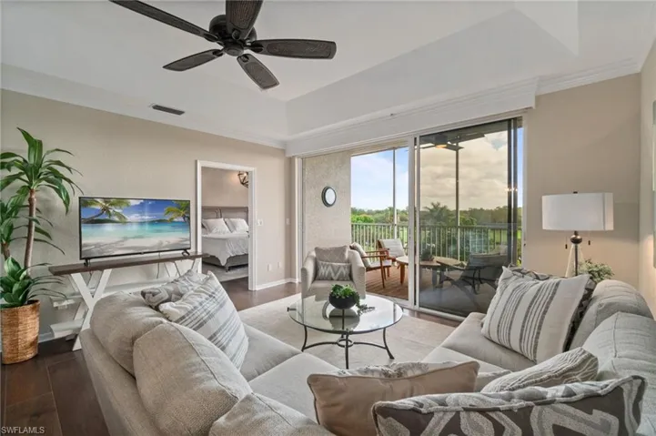 Great room with a vaulted ceiling, wood floors, custom lighting and crown molding.