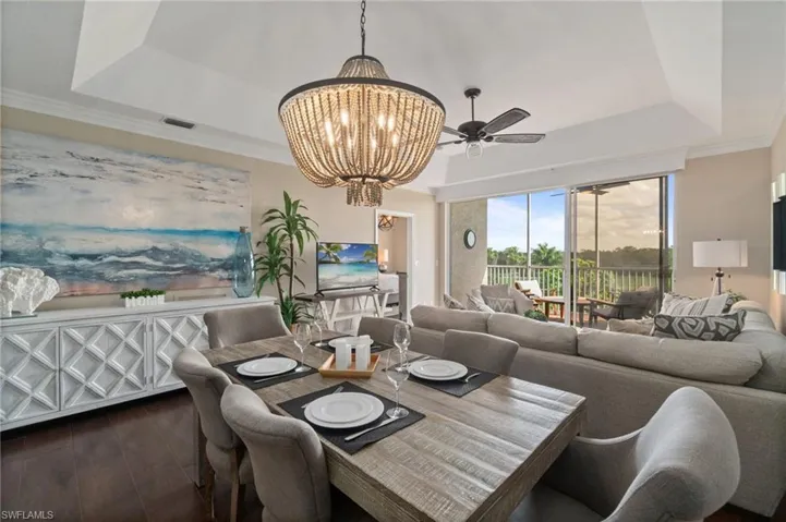 Great room with a vaulted ceiling, wood floors, custom lighting and crown molding.