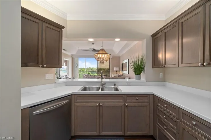 Kitchen with wood cabinetry, stainless steel appliances, wood flooring and recessed lighting.