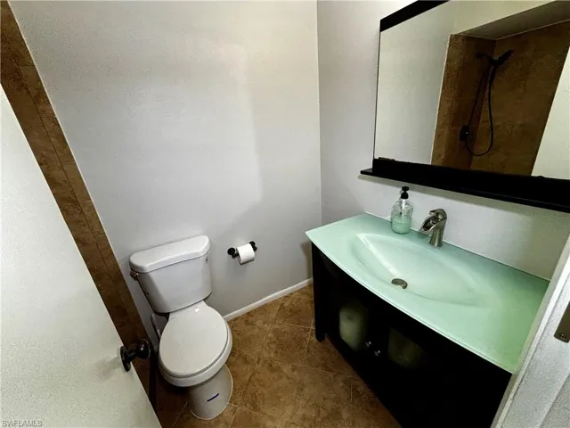 Bathroom with a shower, vanity, toilet, and tile patterned floors