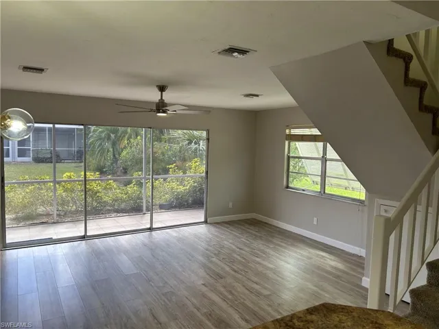 Unfurnished living room featuring hardwood / wood-style flooring, plenty of natural light, and ceiling fan