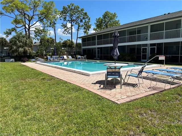 View of swimming pool with a patio and a lawn