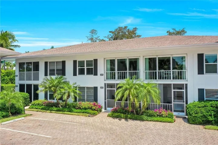 White Building with Black Decorator Shutters, Pink Bougainvillea and Paver Parking