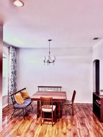 Dining area featuring wood-type flooring and a notable chandelier