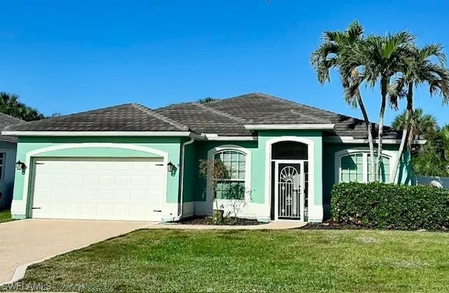 Ranch-style home with a front lawn and a garage