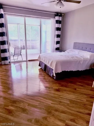 Bedroom featuring hardwood / wood-style floors, ceiling fan, and access to outside