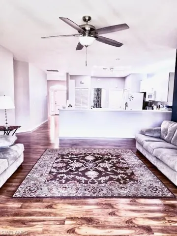 Living room featuring ceiling fan and dark hardwood / wood-style flooring