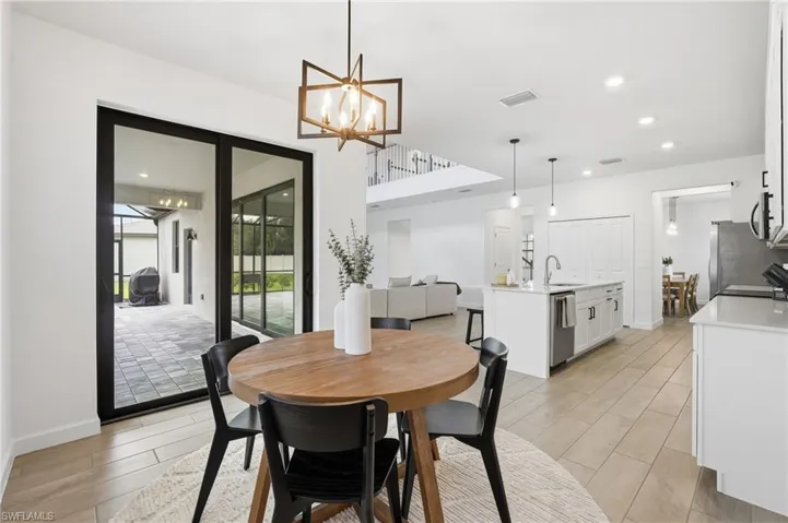 Open-concept interior featuring light wood-finish flooring and white walls